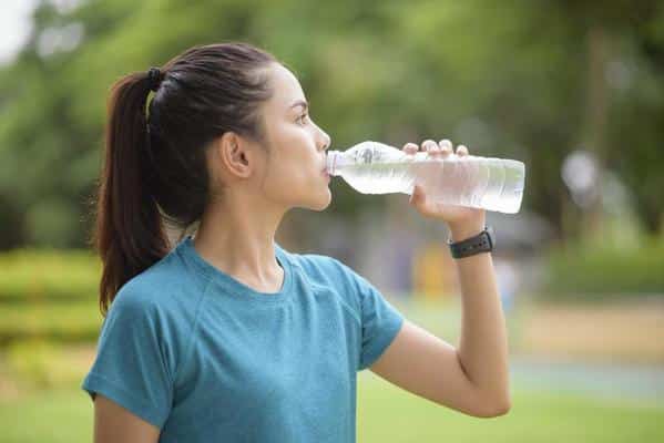 1329883 mulher bebendo agua apos treino em um parque gratis foto 1